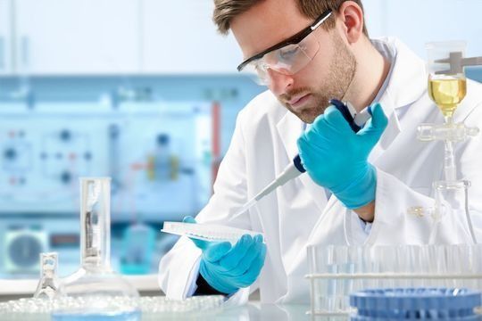 Un científico está trabajando en un laboratorio con una pipeta.