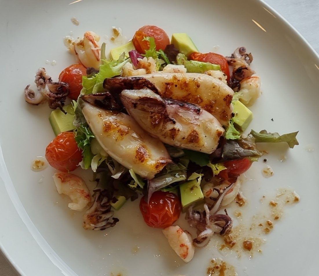 Ensalada de calamares a la plancha con aguacate, tomate y verduras.