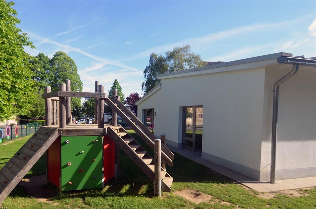 Ein weißes Gebäude mit einem Spielplatz davor