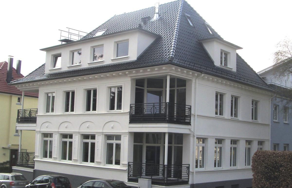 Ein großes weißes Gebäude mit einem schwarzen Dach