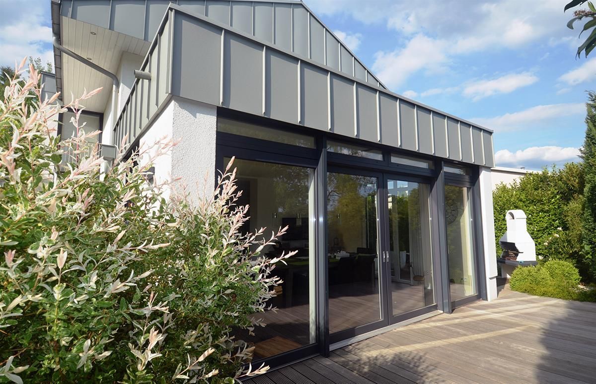 Ein Haus mit vielen Fenstern und einer Glasschiebetür