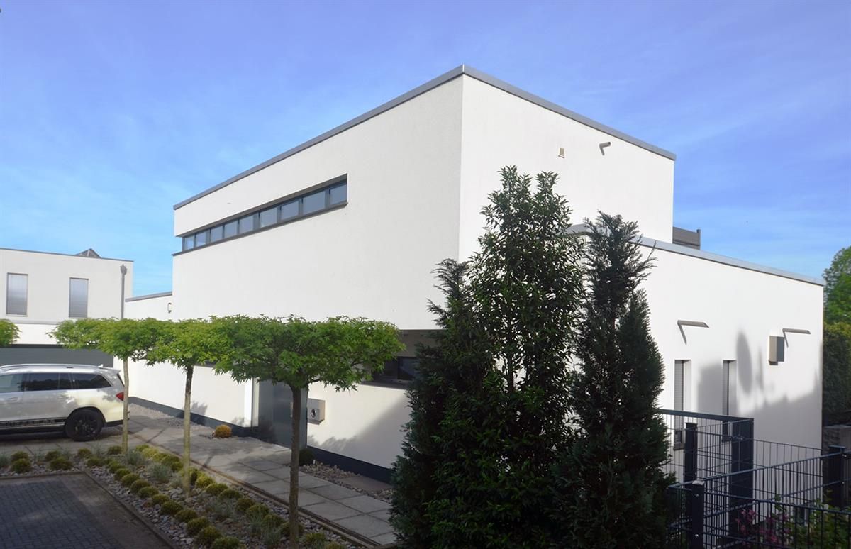 Ein weißes Auto steht vor einem weißen Gebäude