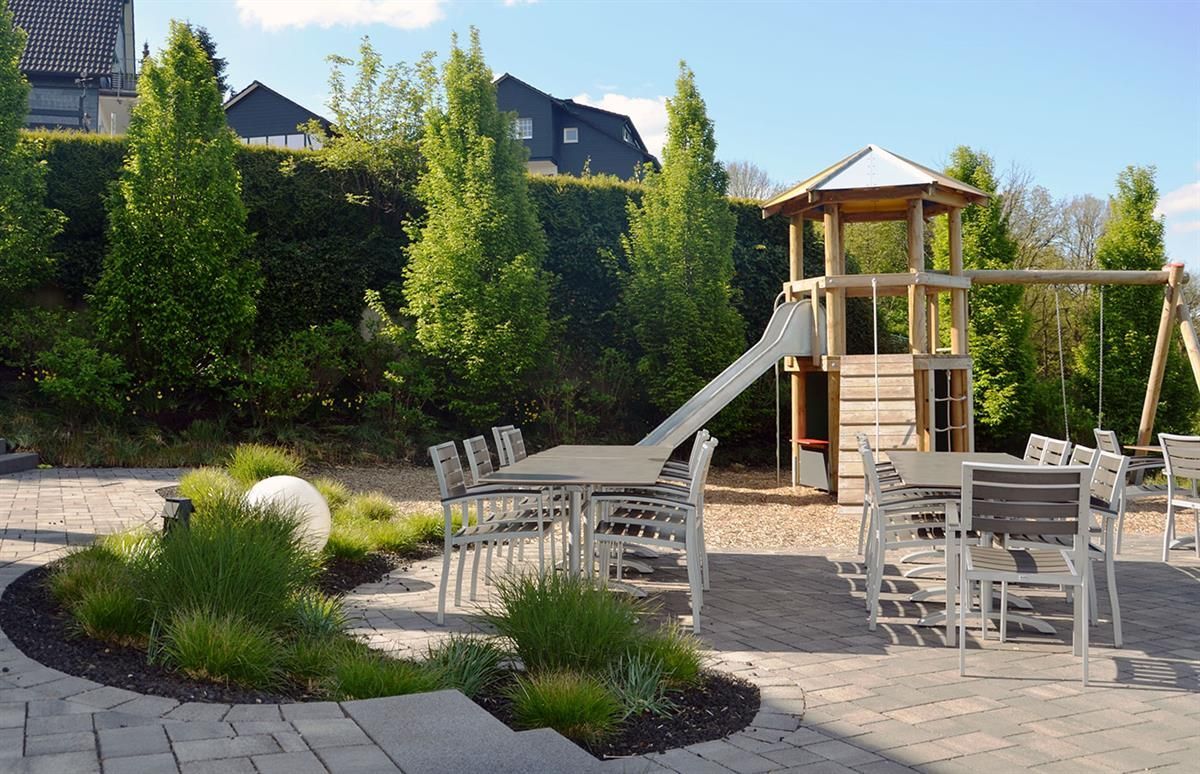 Ein Spielplatz mit Tischen und Stühlen und einer Rutsche