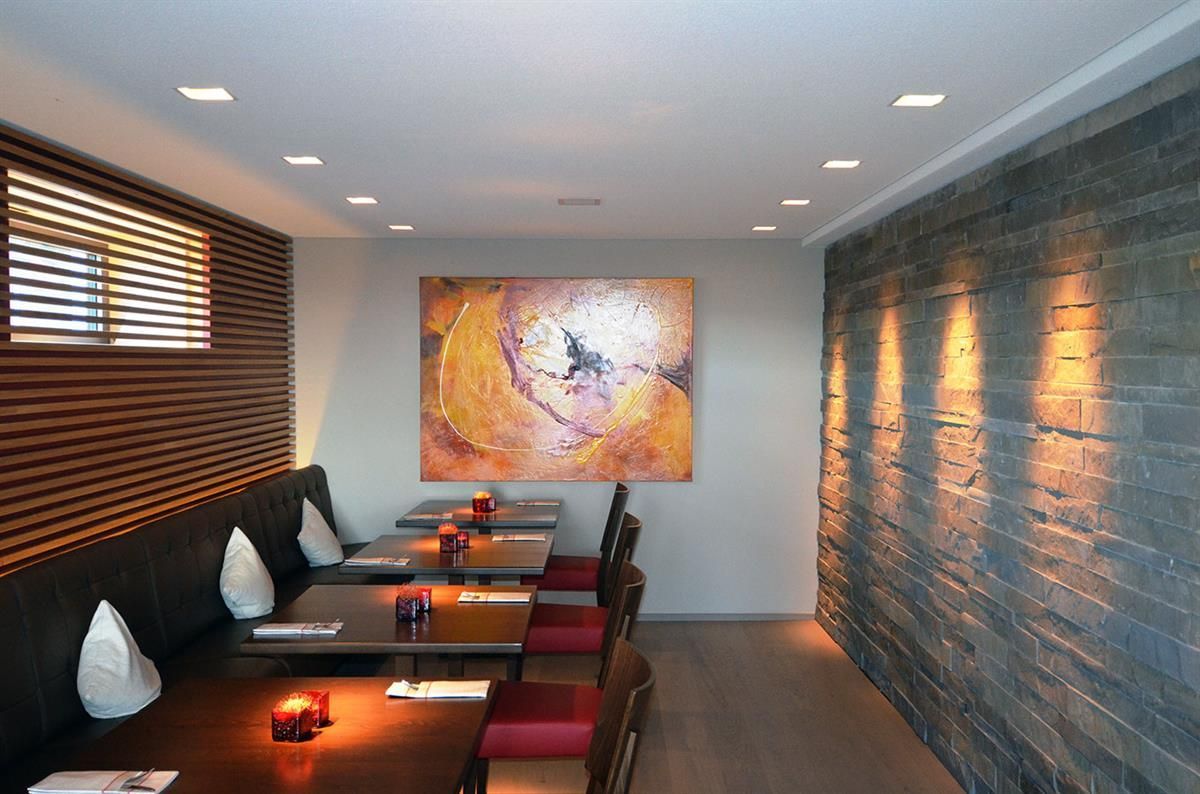 Ein Restaurant mit Tischen und Stühlen und einem Gemälde an der Wand