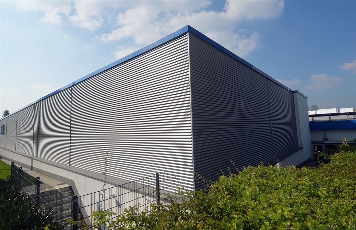 Ein großes Gebäude mit einem blauen Dach und einem Zaun darum