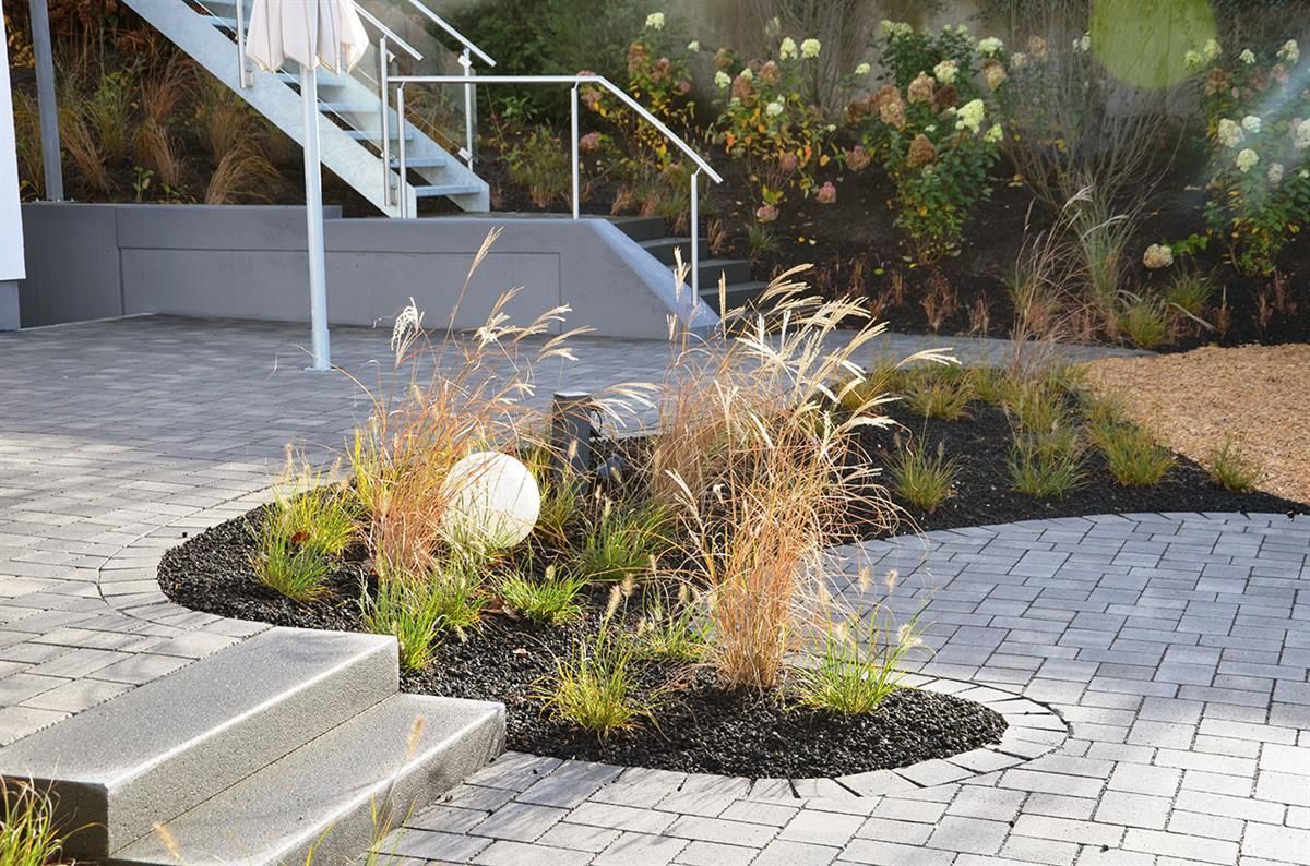 Treppen führen hinauf zu einem Haus mit einem Garten davor