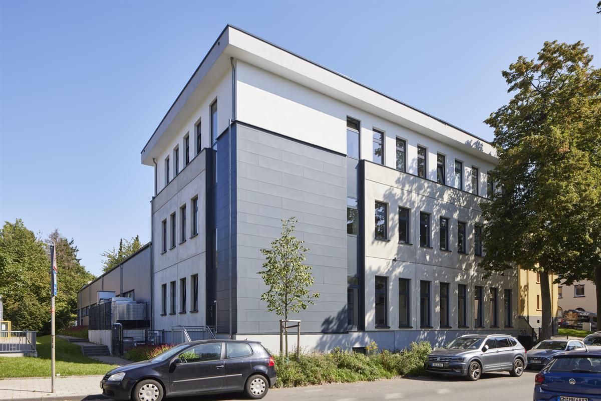 Ein großes Gebäude mit davor geparkten Autos