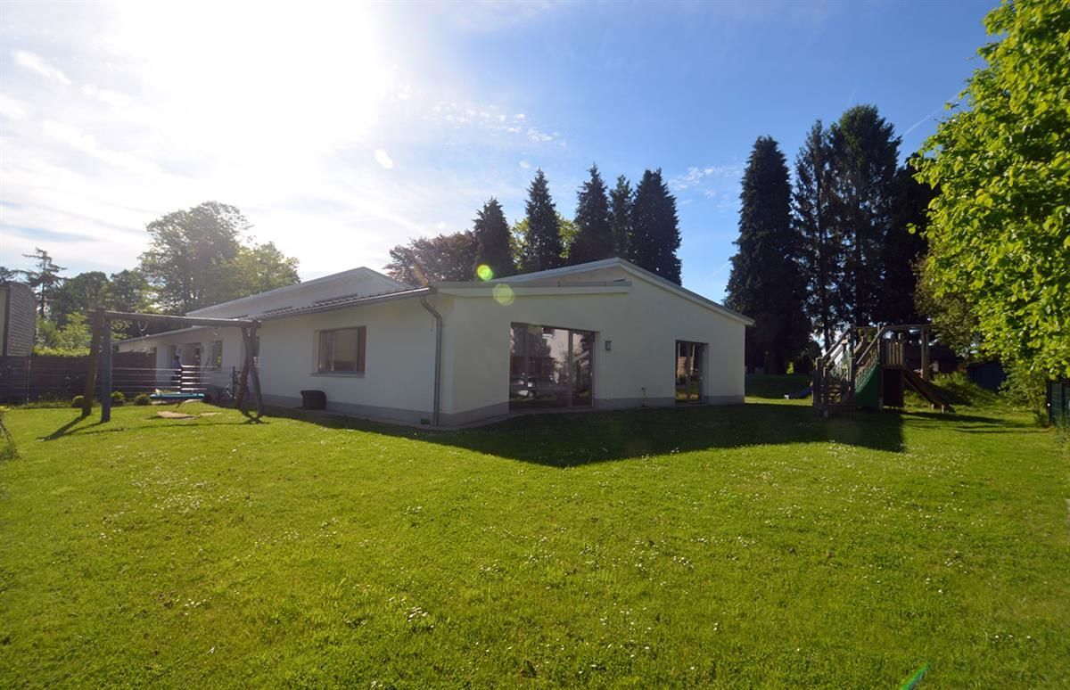 Ein weißes Haus steht inmitten eines üppigen grünen Feldes