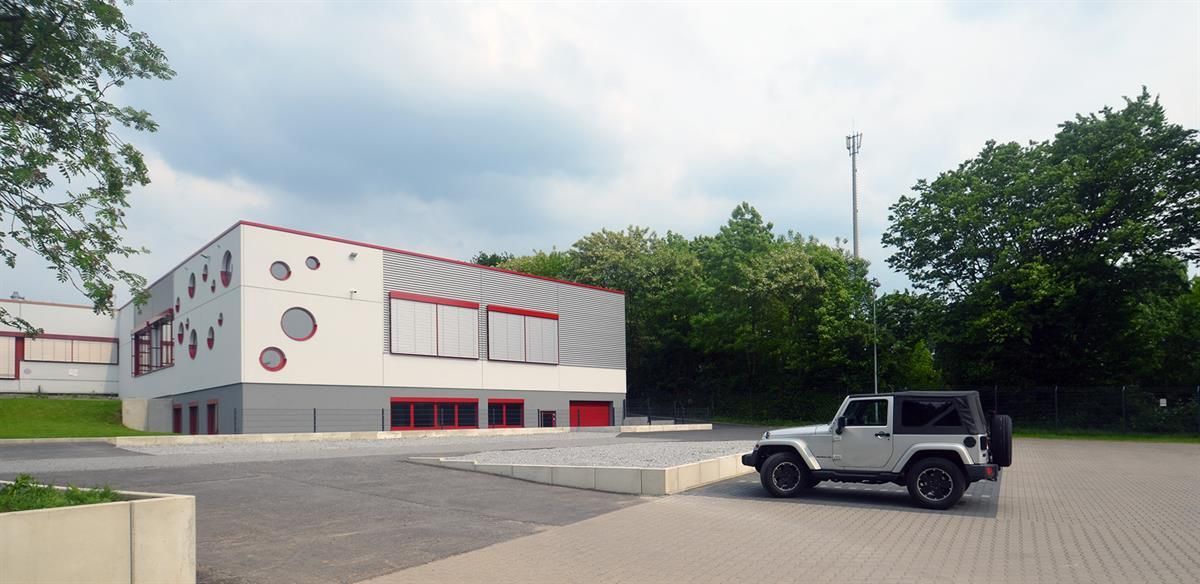 Ein weißer Jeep steht vor einem Gebäude