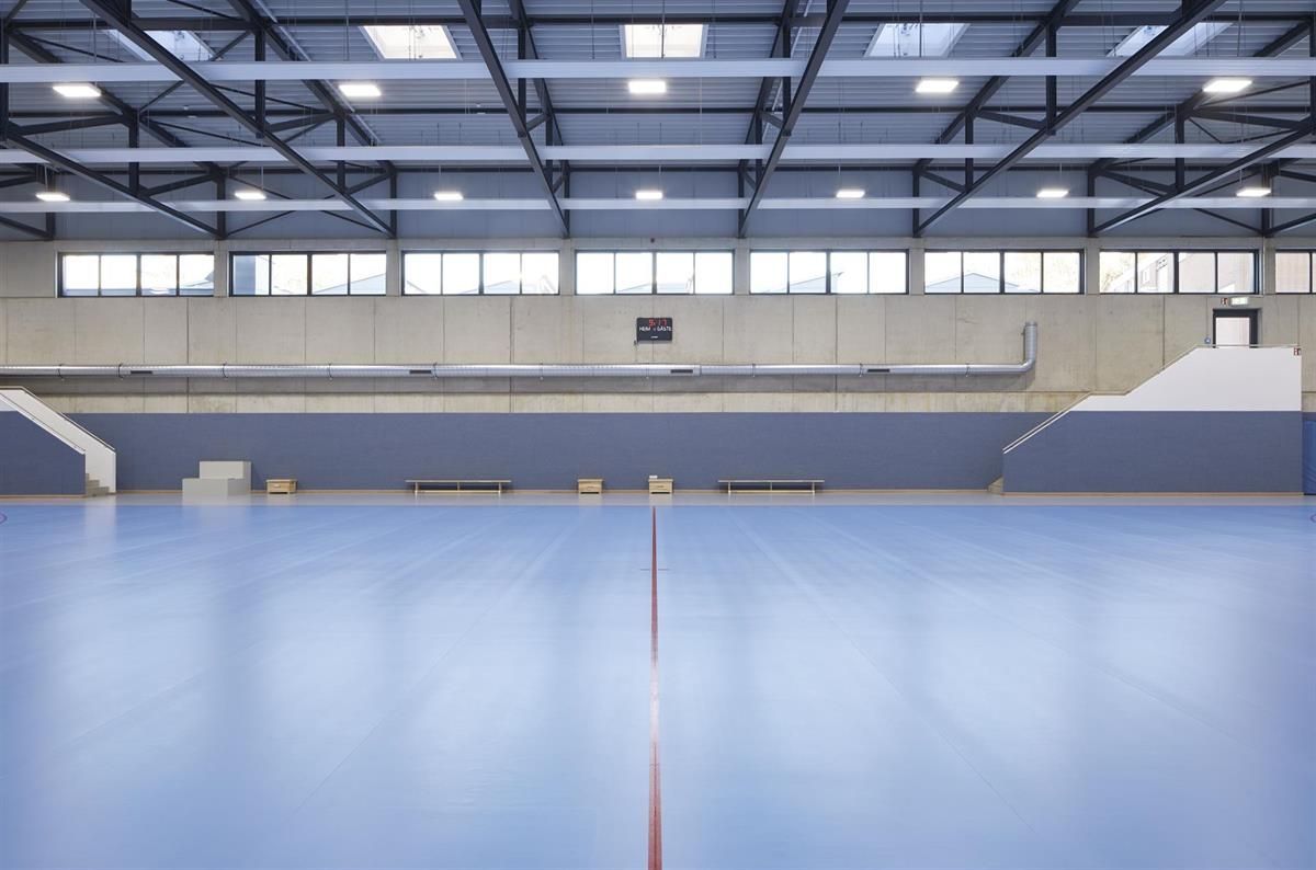 Eine leere Turnhalle mit einem blauen Boden und einer roten Linie