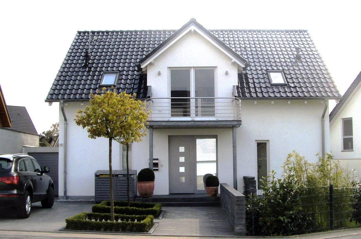 Ein Auto parkt vor einem weißen Haus