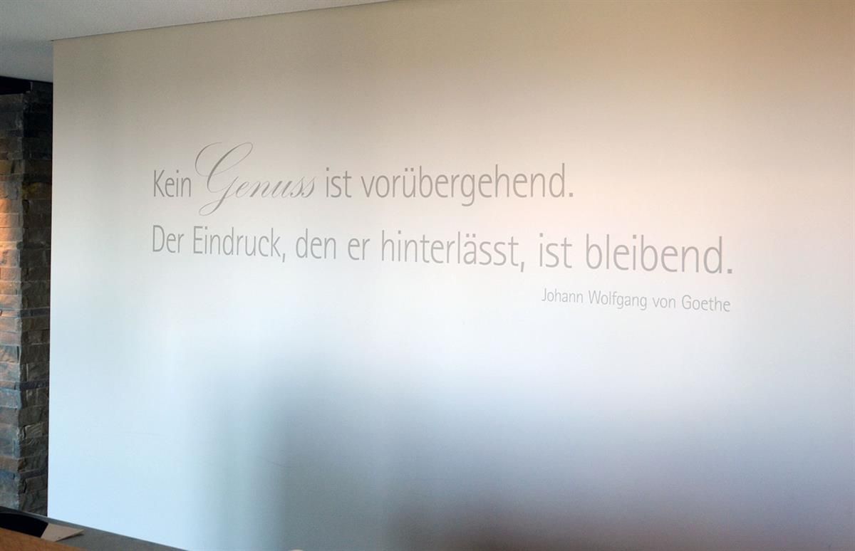 Eine weiße Wand mit einem Zitat auf Deutsch