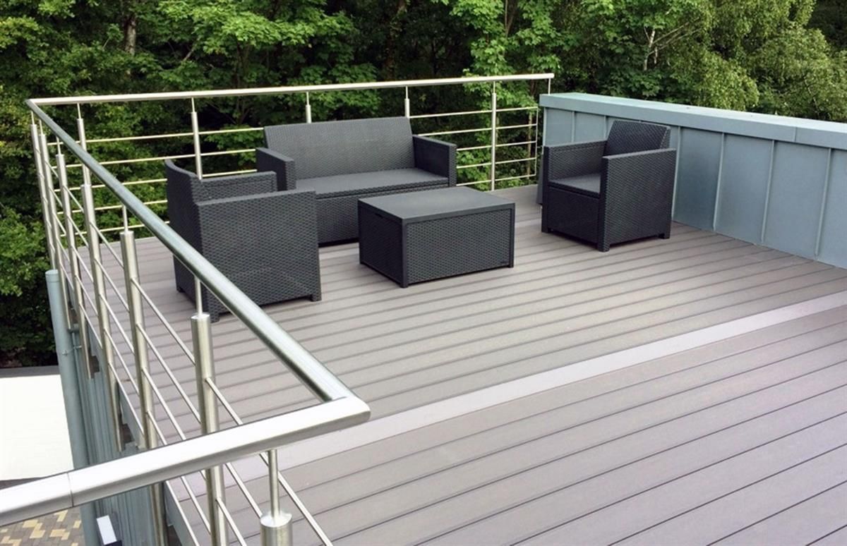 Eine Dachterrasse mit einem Sofa und Stühlen darauf