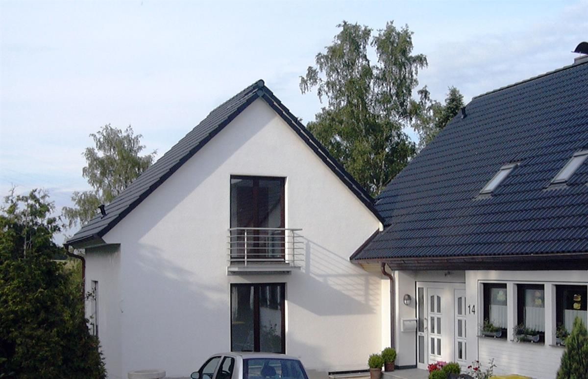 Ein weißes Haus mit einem davor geparkten Auto