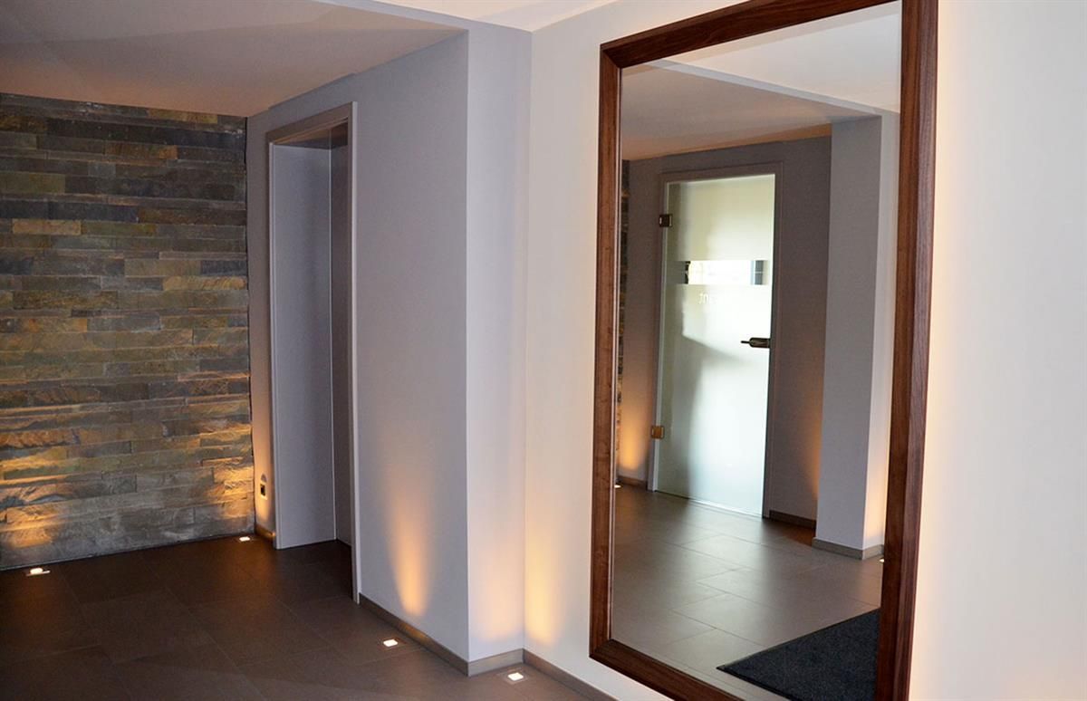 Ein Flur mit einem großen Spiegel an der Wand