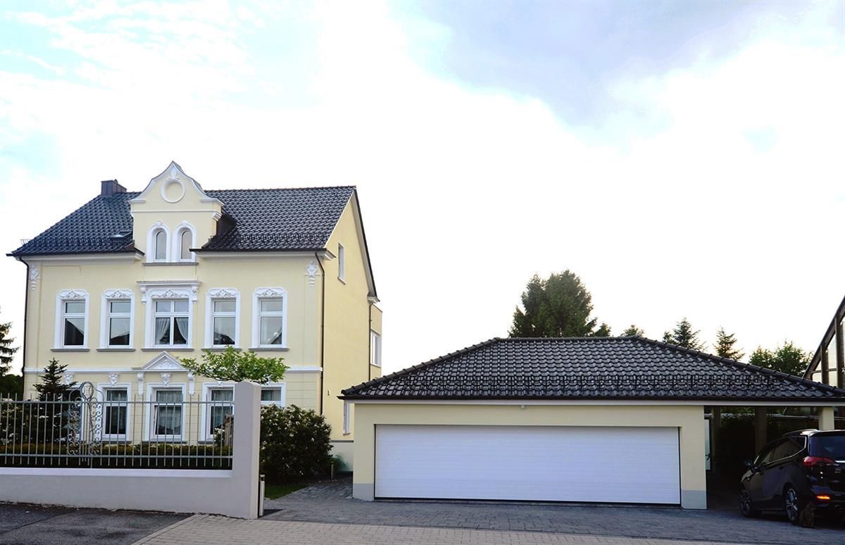 Ein gelbes Haus mit einem davor geparkten Auto