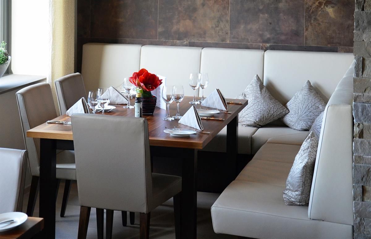 Ein Tisch in einem Restaurant mit einer Vase mit Blumen darauf