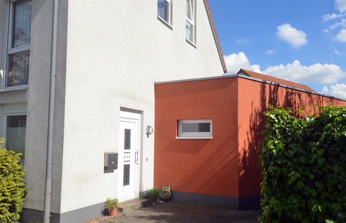 Ein weiß-oranges Haus mit einer weißen Tür