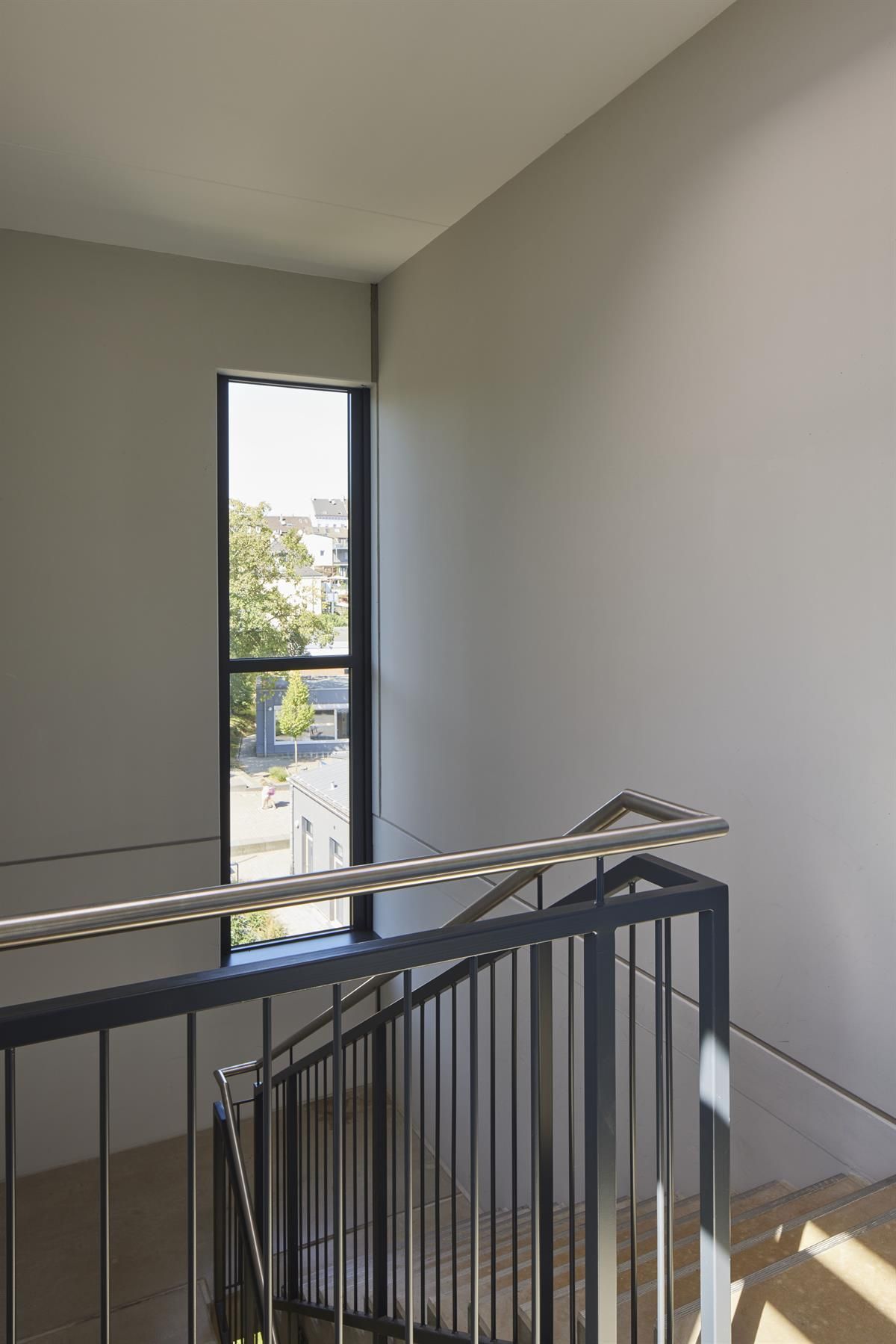 Eine Treppe mit einem Fenster und einem Metallgeländer