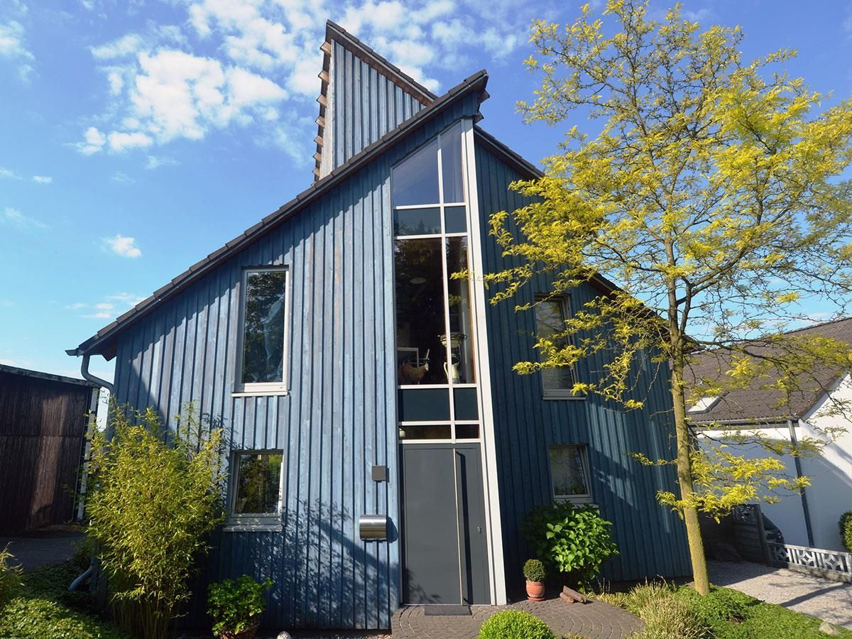 Ein blaues Haus mit einem Baum davor