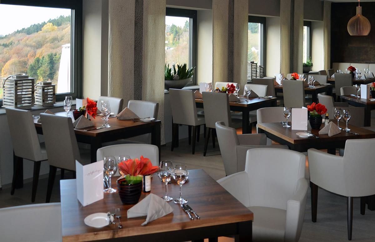 Ein Restaurant mit vielen Tischen und Stühlen und einem großen Fenster