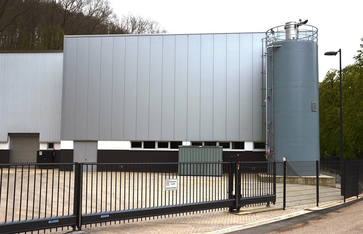 Ein großes graues Gebäude mit einem Zaun darum