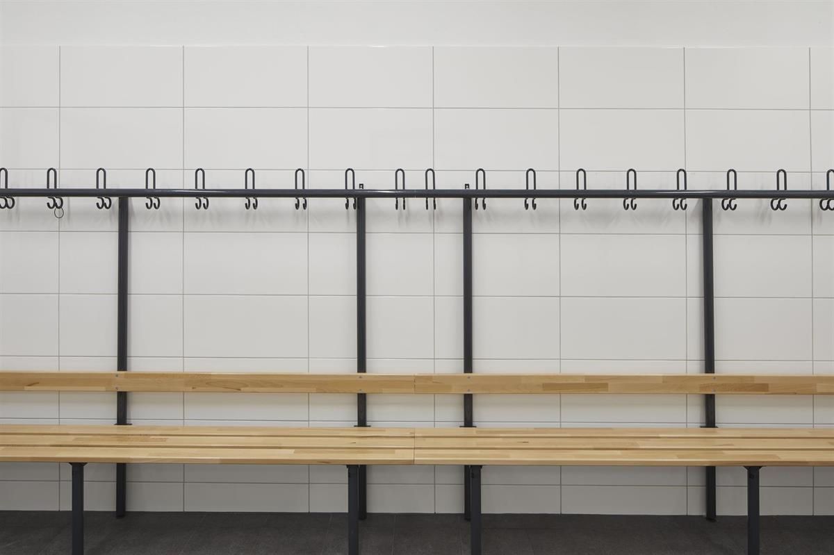 Eine Bank in einer Umkleidekabine mit Haken an der Wand