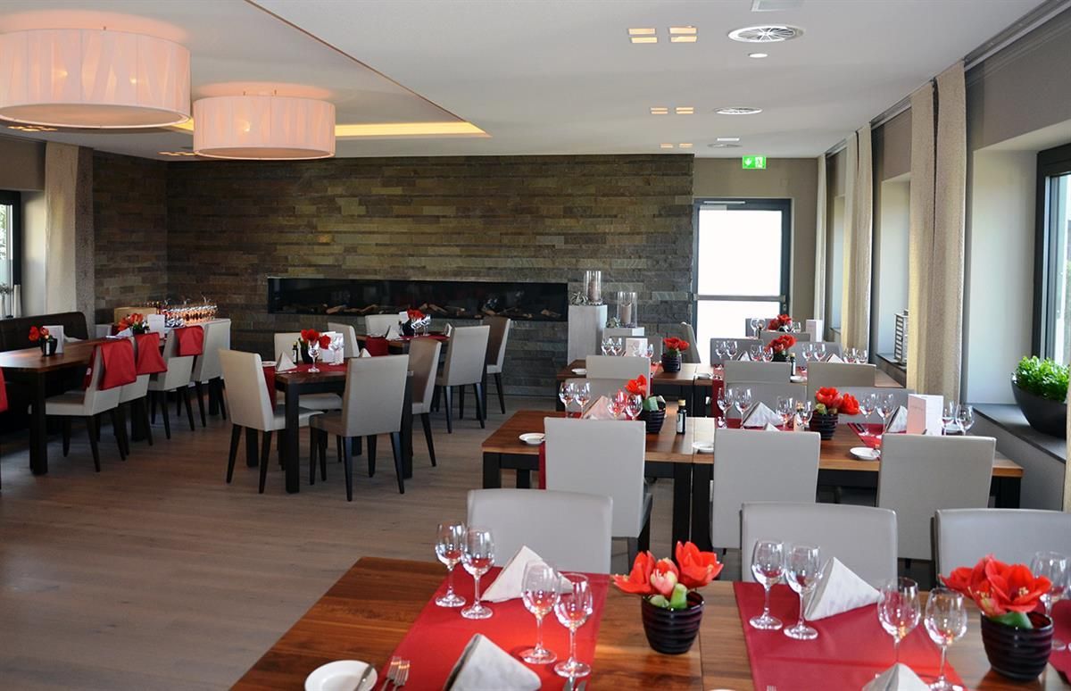 Ein großes Esszimmer mit vielen Tischen und Stühlen