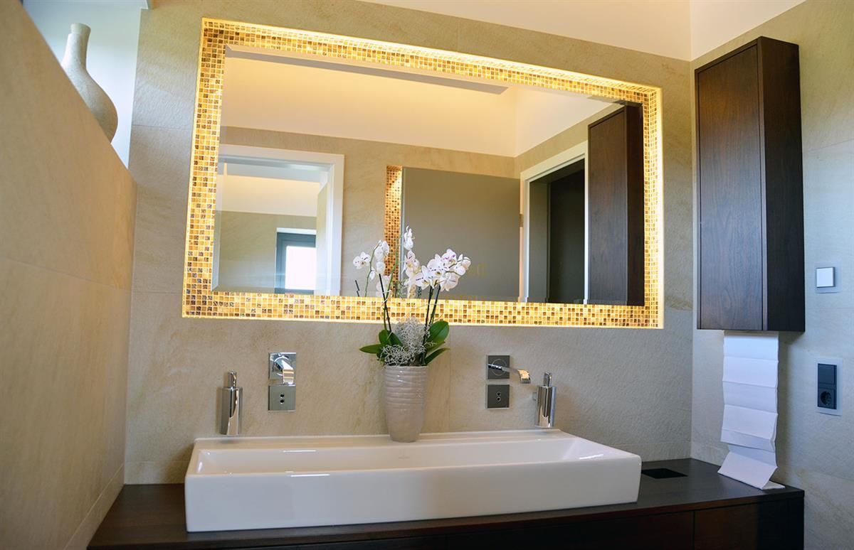 Ein Badezimmer mit großem Spiegel und Waschbecken