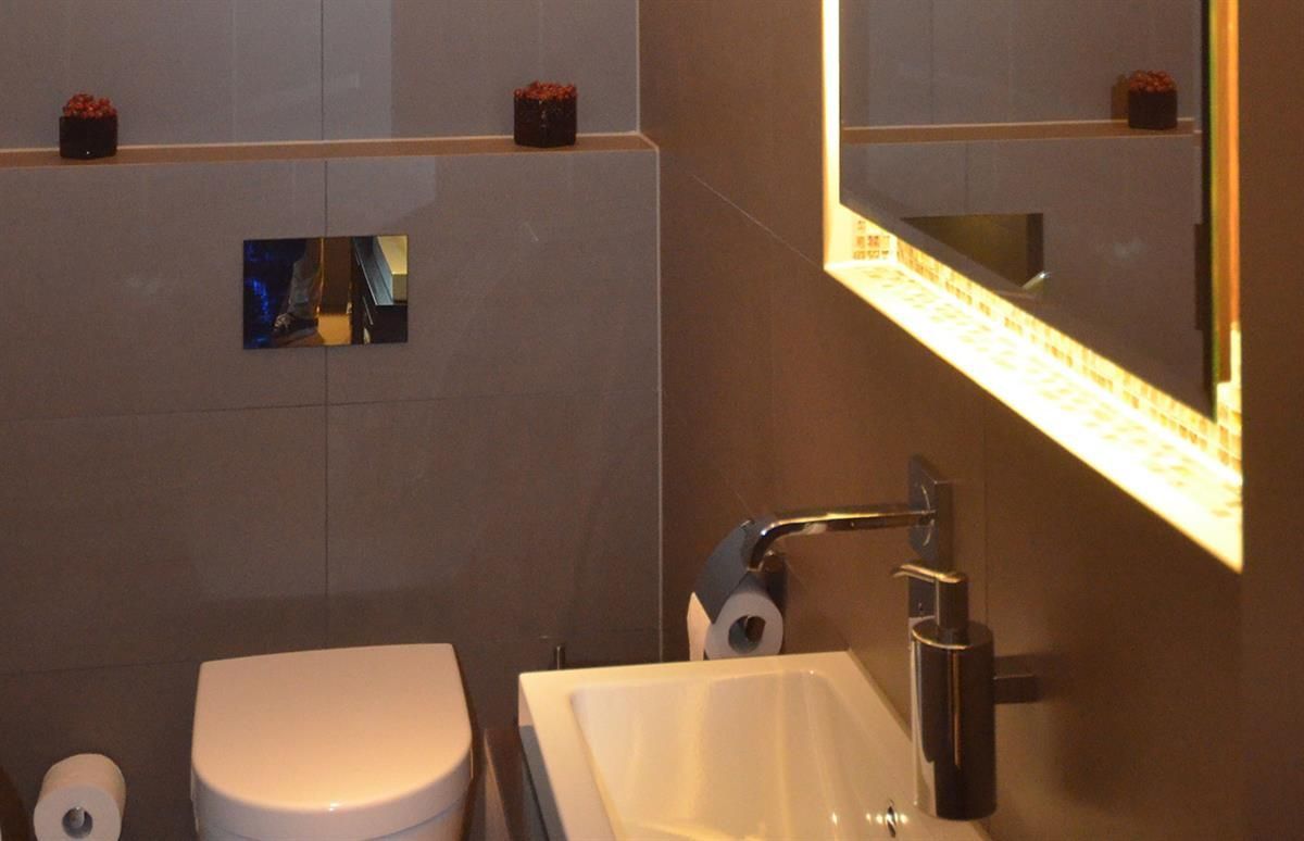 Ein Badezimmer mit Toilette, Waschbecken und Spiegel