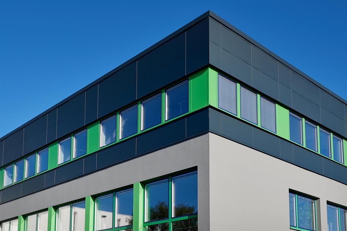 Ein Gebäude mit grünen Fenstern und einem blauen Himmel im Hintergrund