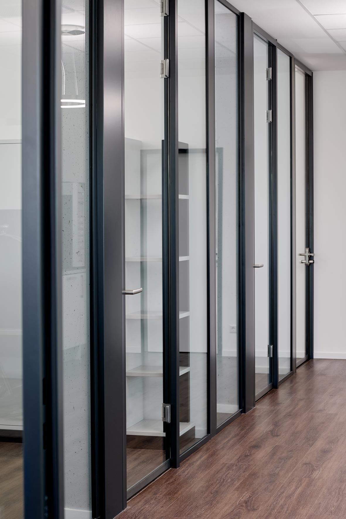 Ein Flur mit vielen Glaswänden und Türen
