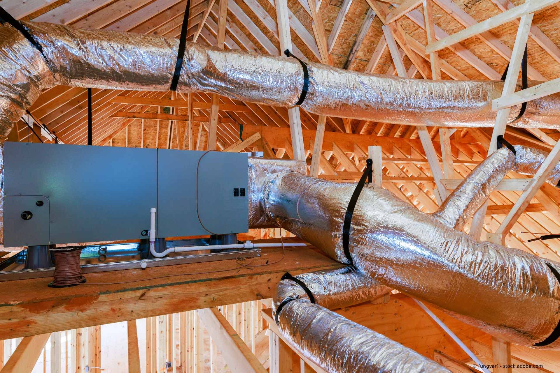 Eine Klimaanlage mit Luftaufbereitungsanlage ist an flexible, silberisolierte Luftkanäle angeschlossen