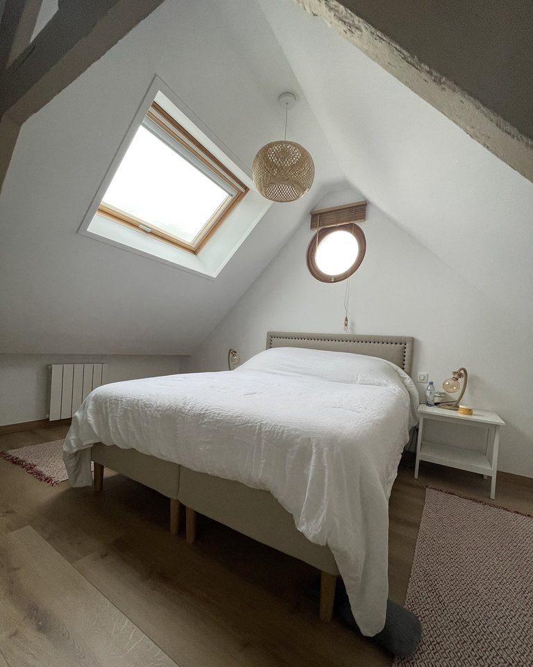 Chambre avec un lit blanc fait