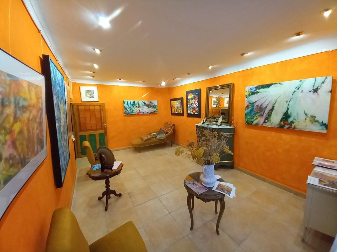 Textil batik abstracto. Fondo rojo, morado y azul con rayas pálidas entrecruzadas y motivos circulares.