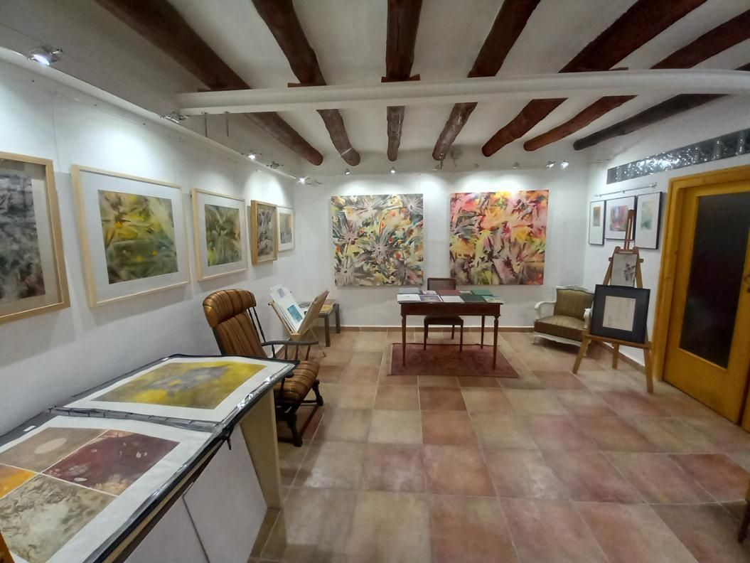 Obra de arte abstracta con círculos y rectángulos rojos, dorados y blancos sobre un fondo rojo oscuro