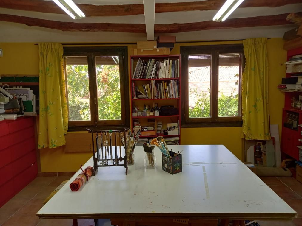 Arte abstracto con formas circulares superpuestas de color amarillo y negro sobre un fondo blanco.