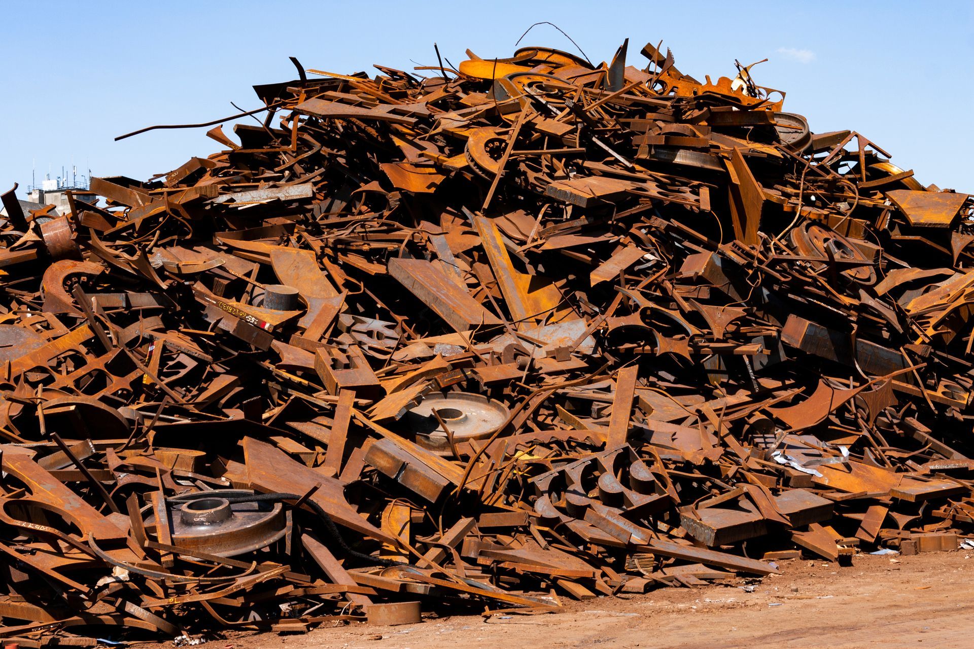 Un vaste amas de ferraille rouillée et de débris industriels s'étendait sous un ciel d'un bleu éclatant.