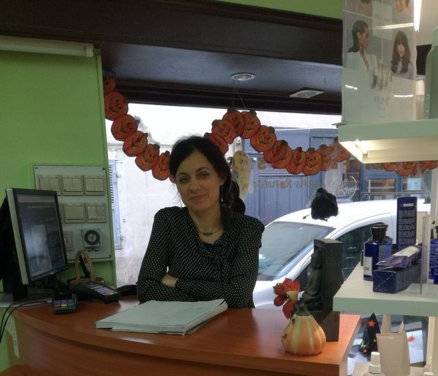 Femme accoudée à l'accueil du salon de coiffure