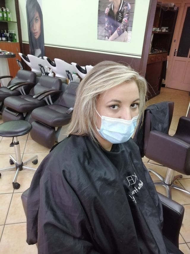 Femme blonde portant un masque et une blouse vue en plongée