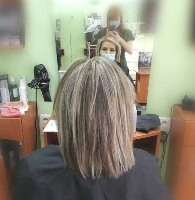 Femme en blouse de protection avec cheveux blonds méchés