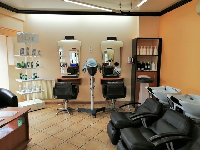 Salon de coiffure avec fauteuils de coiffure et bacs à shampoing