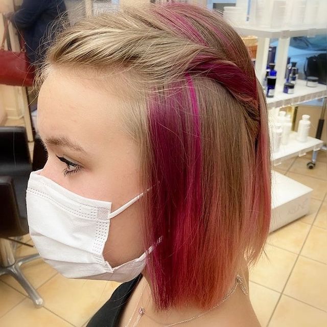 Adolescente de profil avec cheveux au carré et mèches roses