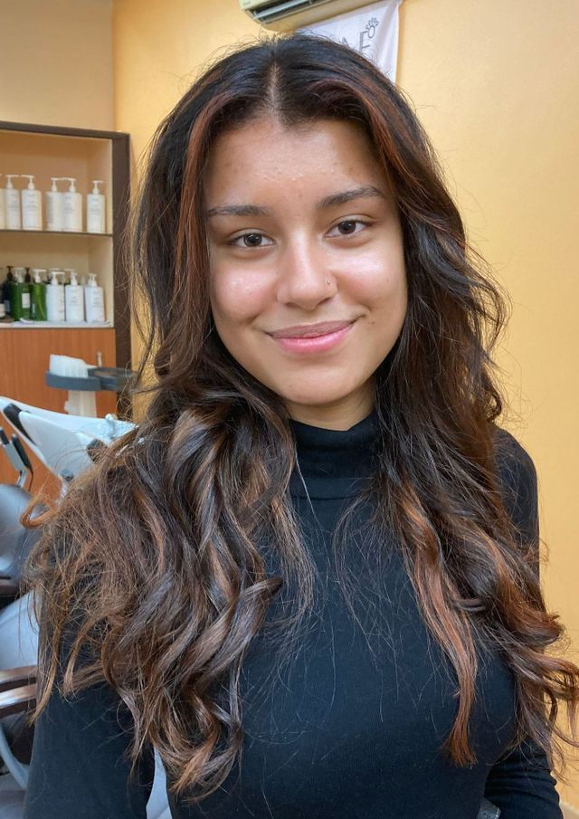 Adolescente avec cheveux longs bouclés et mèches auburn