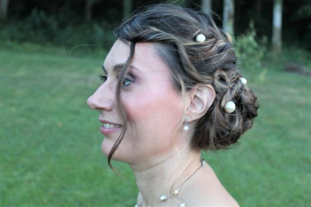 Chignon avec perles et mèche de cheveux qui entoure le visage