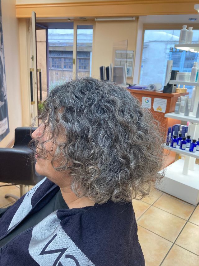 Cheveux mi-longs et bouclés poivre et sel
