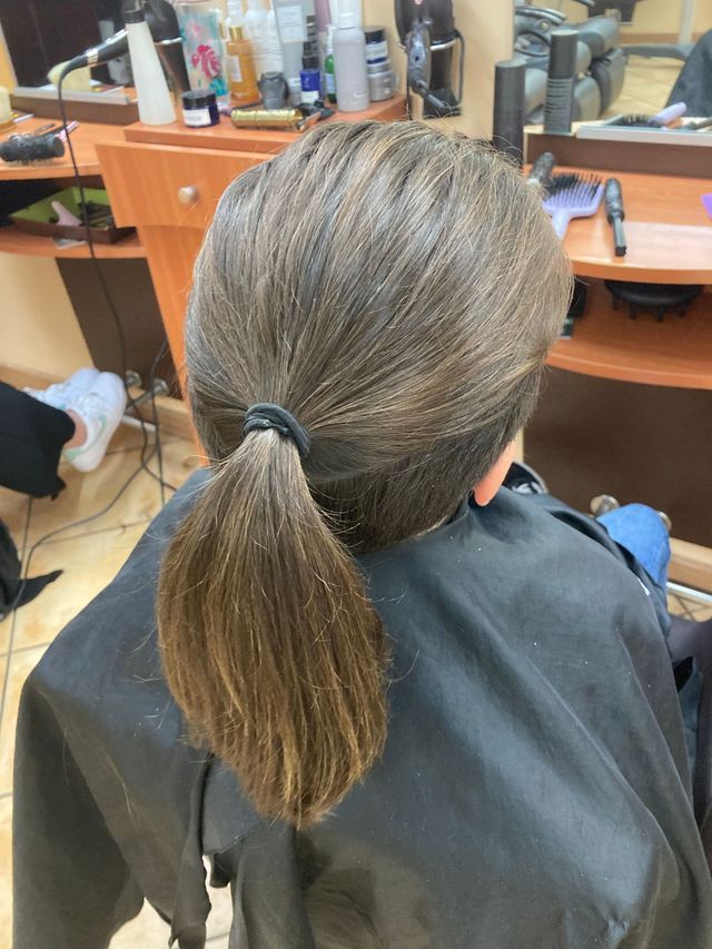 Cheveux longs relevés en queue-de-cheval rasés sur les côtés