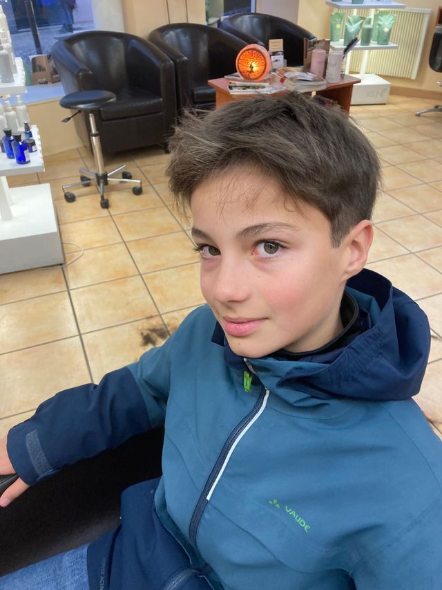 Garçon avec cheveux courts et coupe-vent à capuche bleu