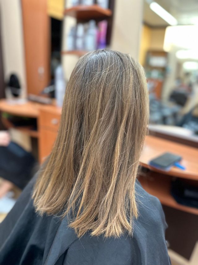 Personne de dos avec cheveux châtains lisses et reflets bonds