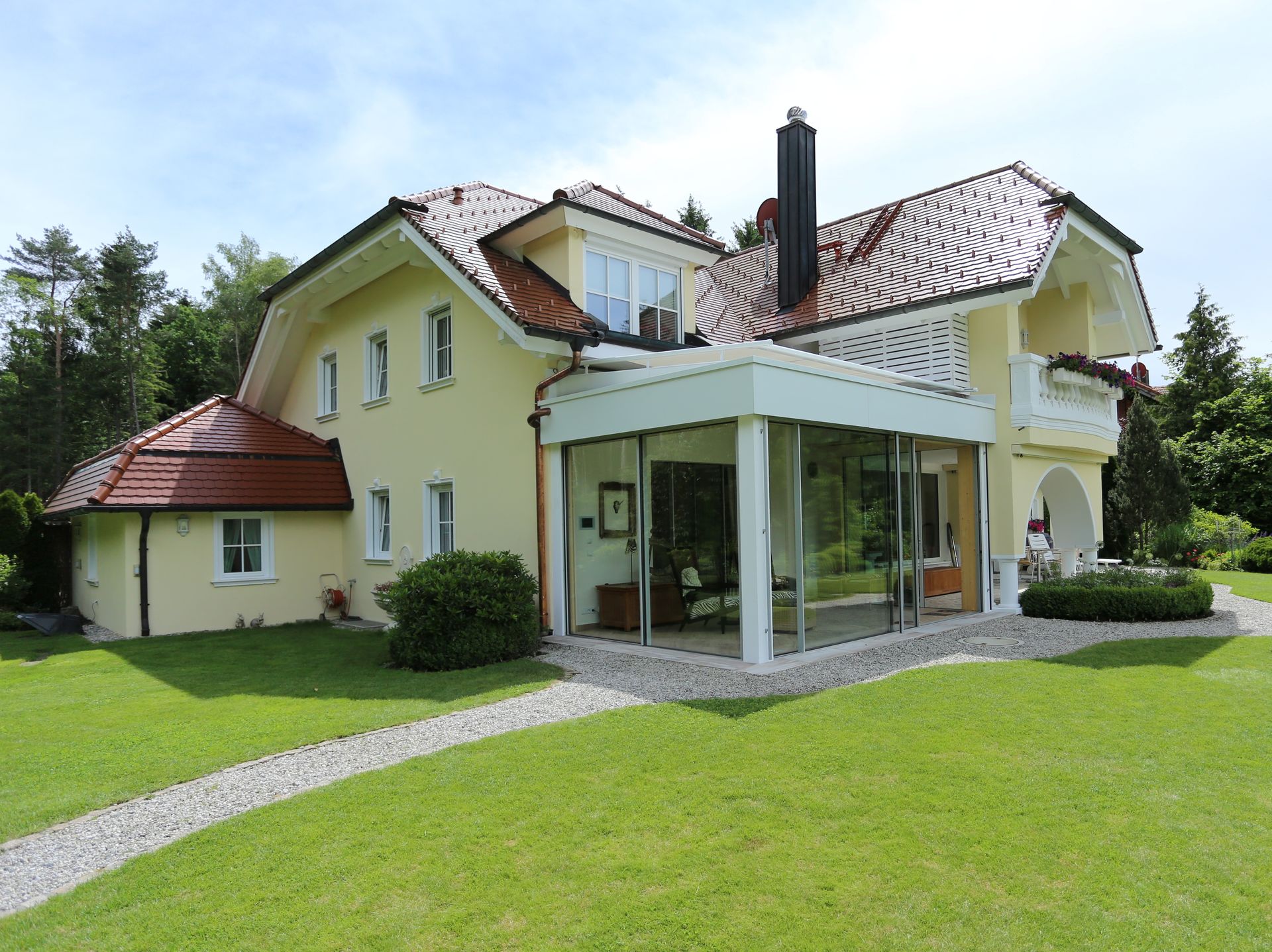 ein großes gelbes Haus mit einem roten Dach und vielen Fenstern